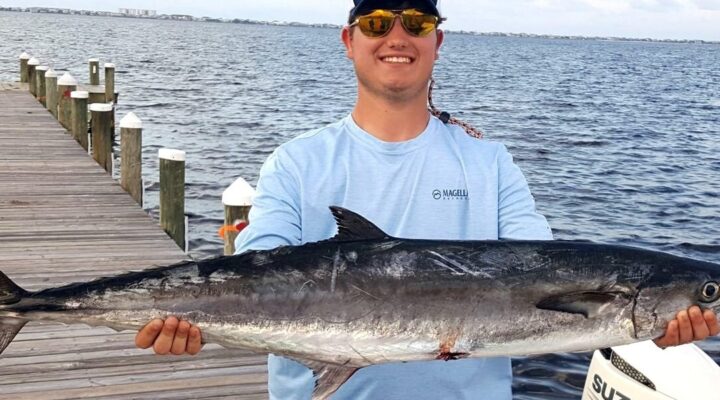 Young angler holding a king mackerel
