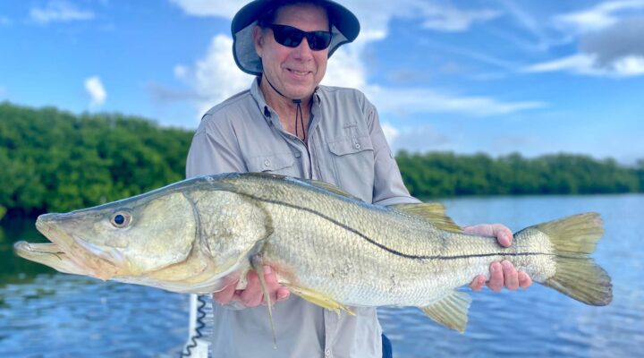 White Pearl Fishing angler holding a snook