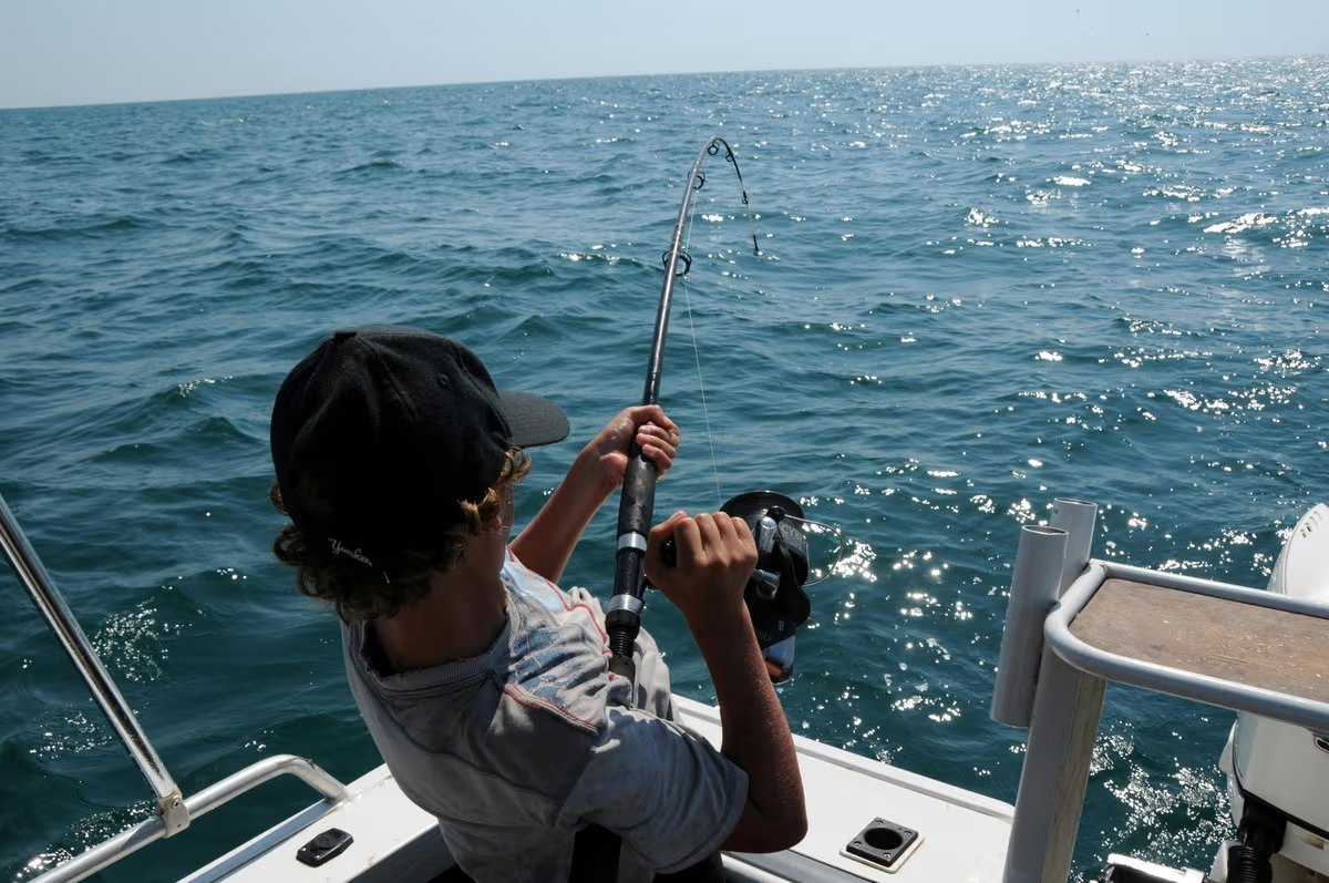 Young angler fighting a fish from the stern with Linda D Sportfishing