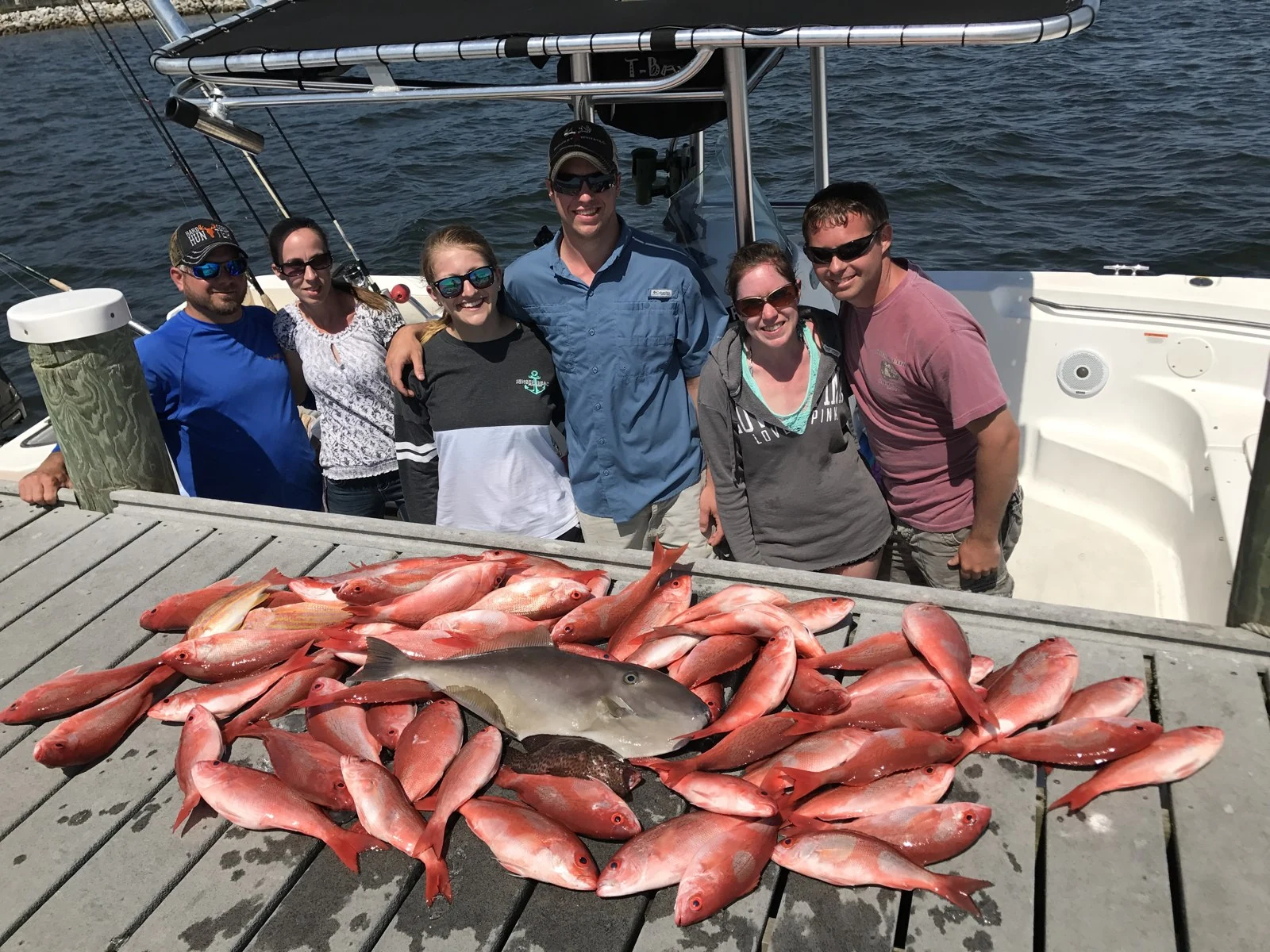A Bout Time group stands behind its snapper catch aboard the boat