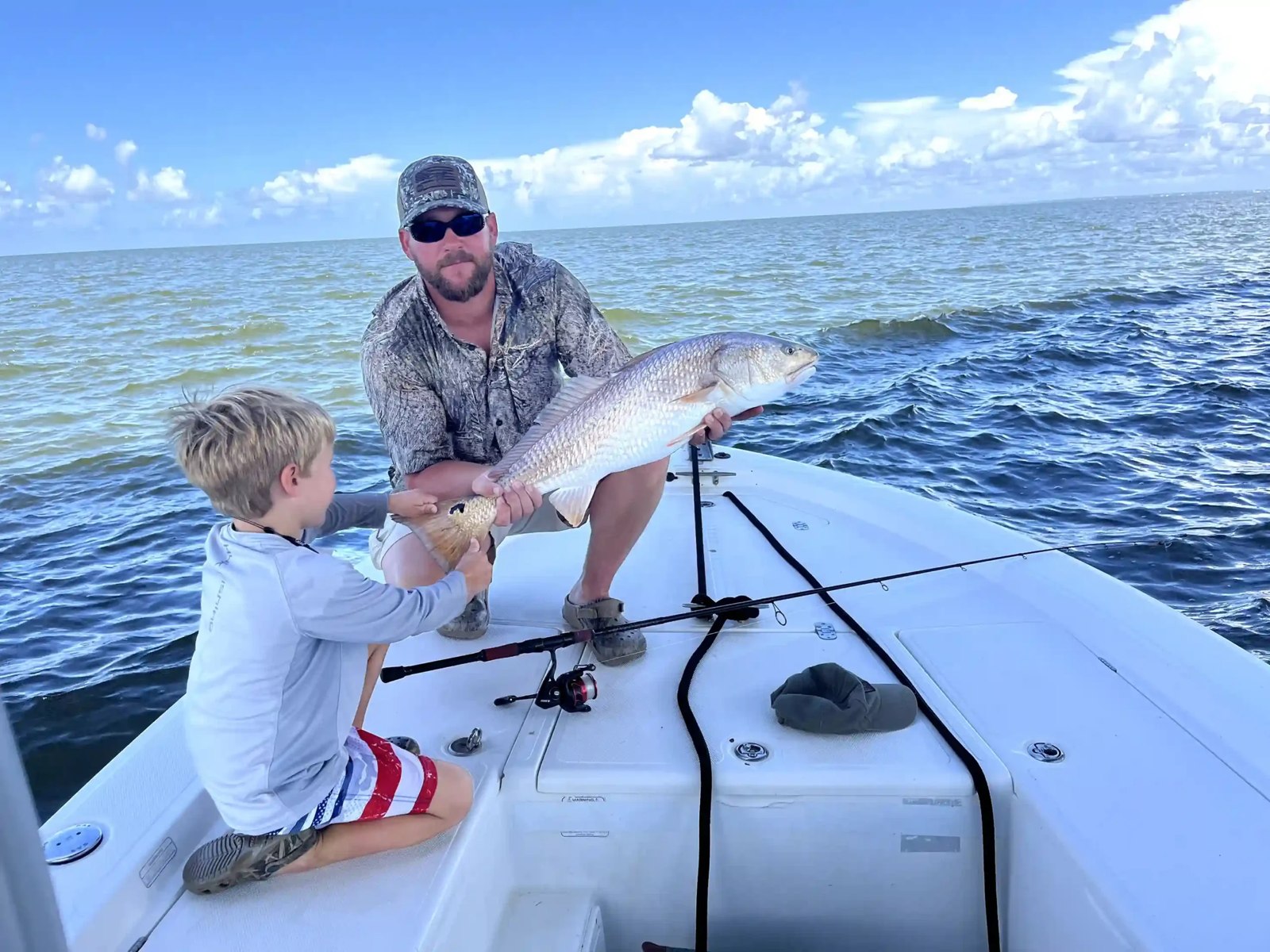 Adult and child displaying a catch on an Apalachicola Guide Service boat