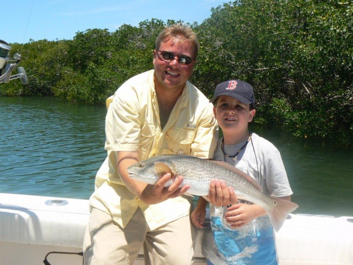 Adult and young angler showing a redfish on a Fishburger Charters outing