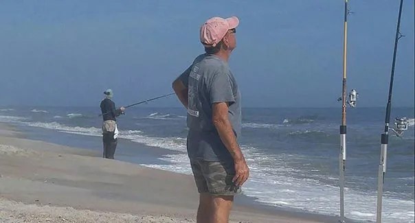 Amelia Angler surf fisherman beside rods on the beach