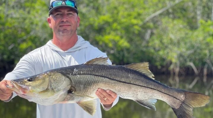 Angler displaying a large snook on a Fish Often charter