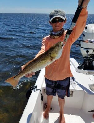 Angler displaying a redfish with Steinhatchee Fishing Charters