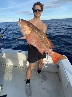 Angler displaying a snapper on a Reel Intense fishing trip