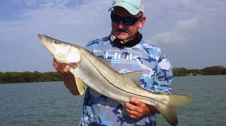 Angler displaying a snook on Captain Steve Hogan’s boat