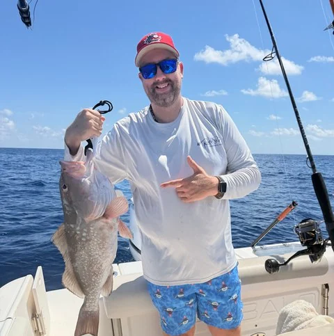 Angler holding a fish aboard JoyFish Charters