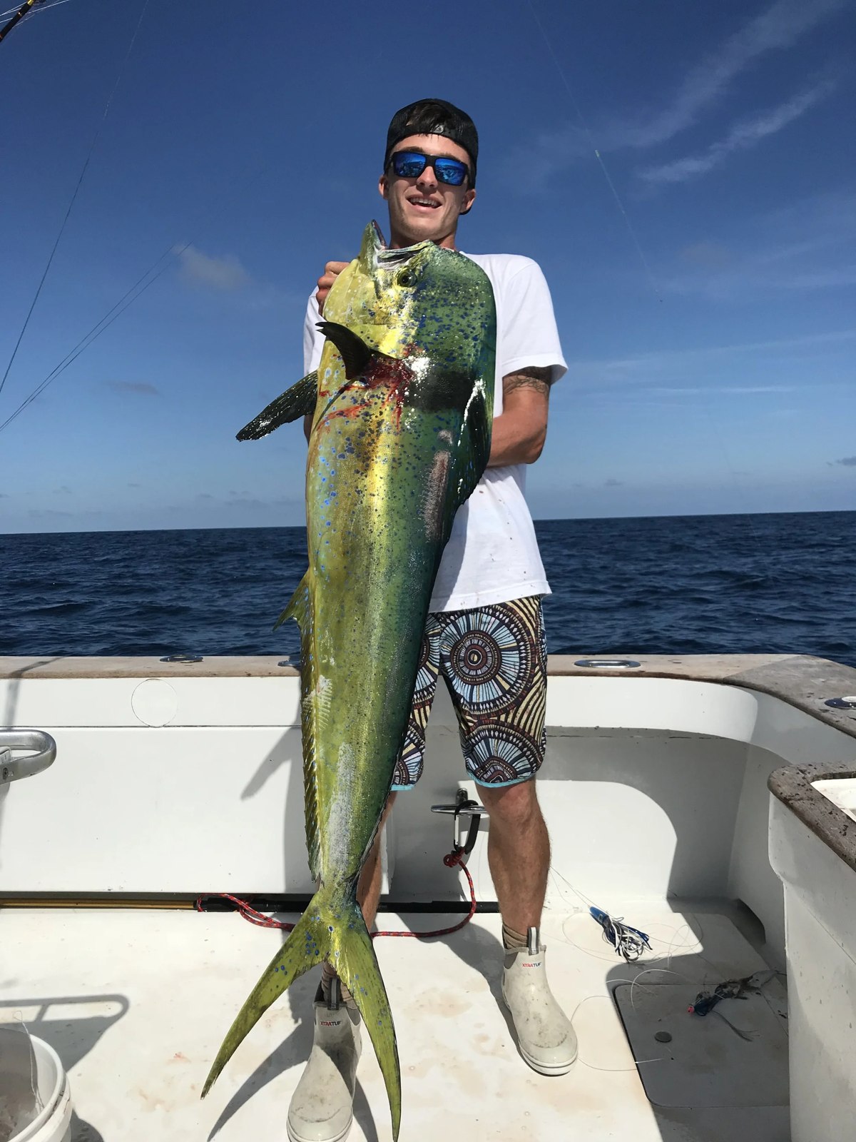 Angler holding a mahi mahi aboard Drop Down Charters