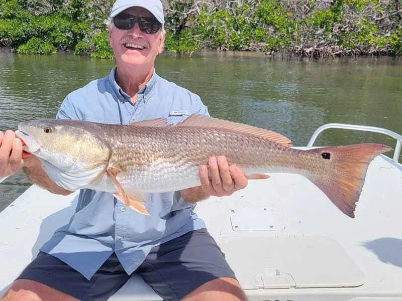 Angler holding a redfish on a Charley’s Fishing Charters outing