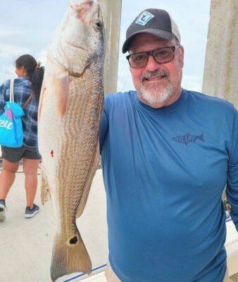 Angler holding a redfish with Rod Bender Fishing Charters