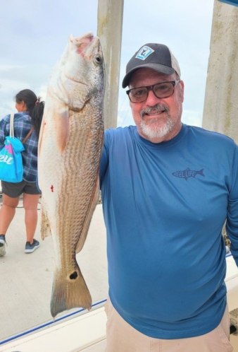 Angler holding a redfish with Rod Bender Fishing Charters