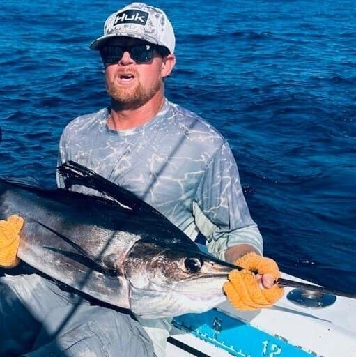 Angler holding an offshore fish during a Captain Jonny's charter
