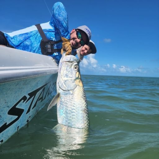 Angler lifting a tarpon beside Captain Rick Stanczyk's boat