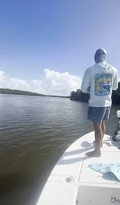 Angler standing on the bow while fishing calm water