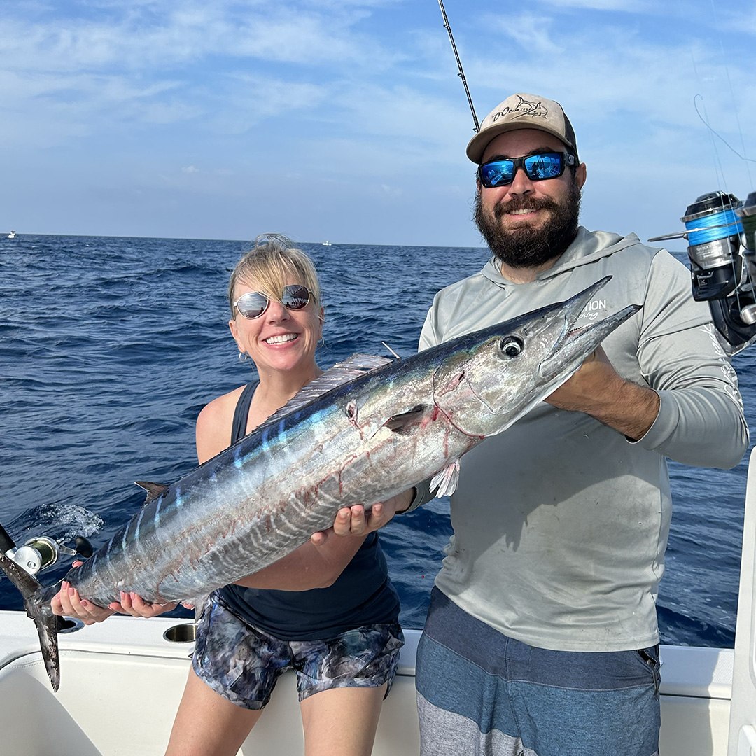 Anglers displaying a barracuda on a Wall To Wall fishing trip