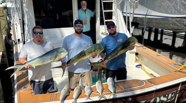 Anglers displaying mahi at the stern of Hate 2 Lose