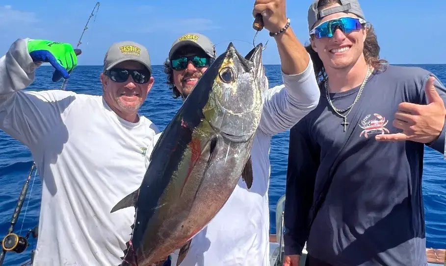 Anglers holding an amberjack aboard Testify Charters