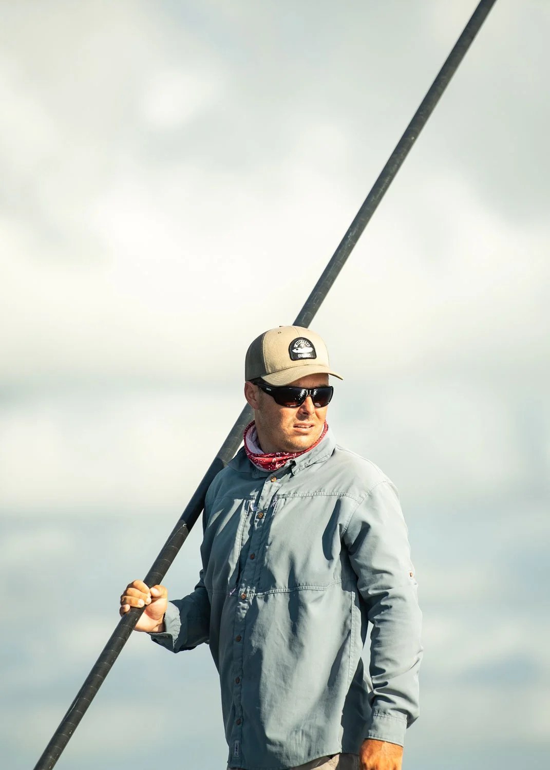 Captain Lincoln Rodriguez holding a push pole on his skiff