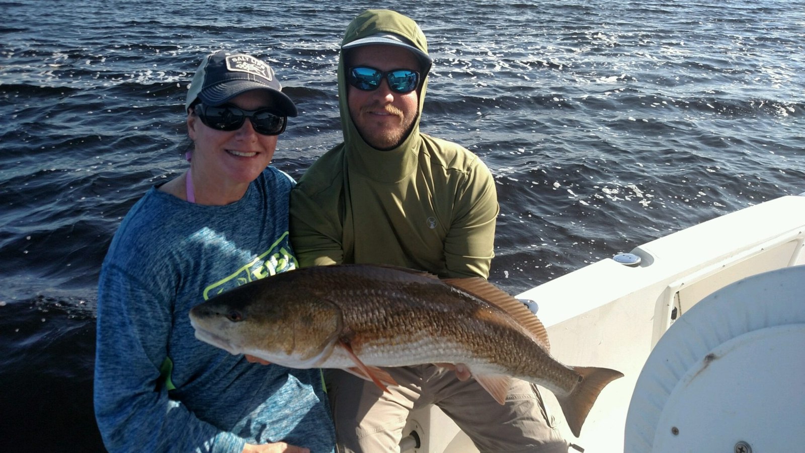 Captain Major fishing guests holding a redfish