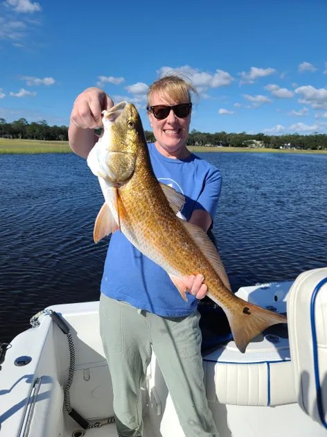 Daytripper Marine Services angler holding a redfish