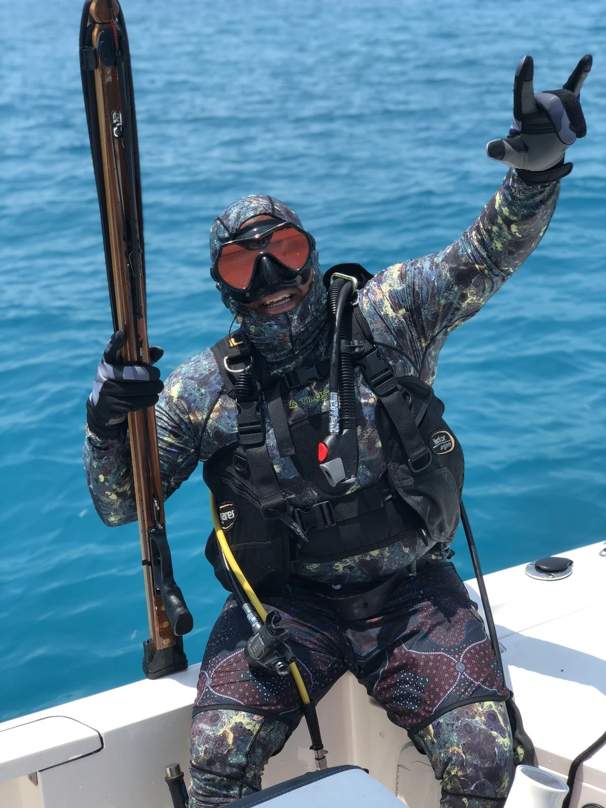 Diver aboard a Wrecked Charters boat holding spearfishing equipment