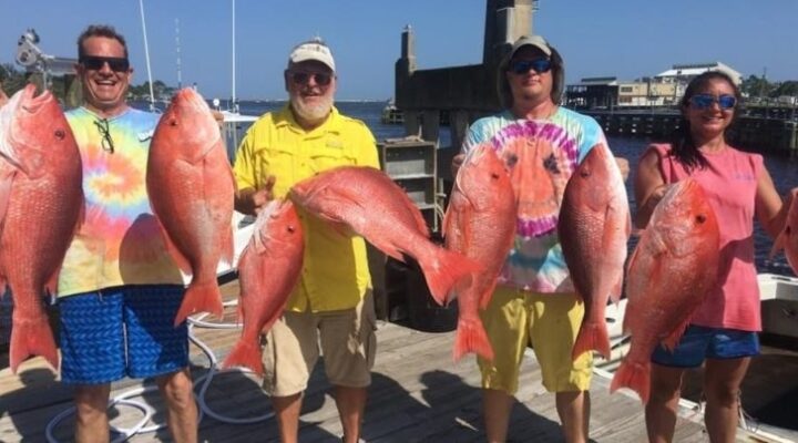 Entertainer fishing guests holding red snapper