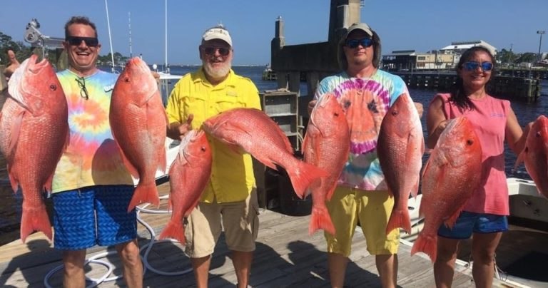 Entertainer fishing guests holding red snapper