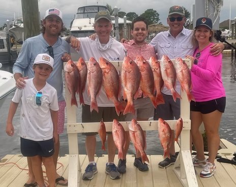 Family displaying a red snapper catch with Blue Sky Fishing 30A