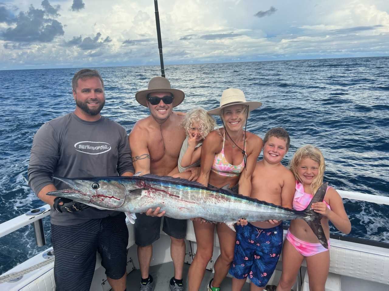 Family displaying a wahoo with Seahorse Fishing Adventures