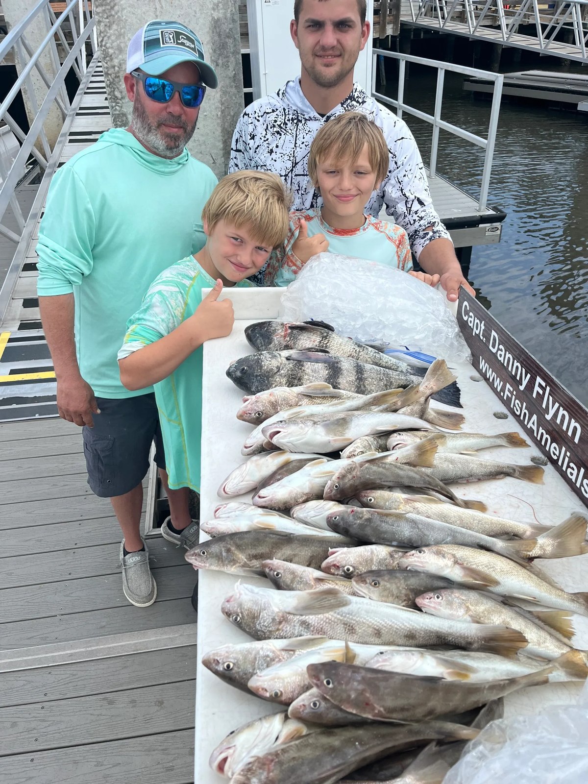 Fish Amelia Island family beside a table of their catch