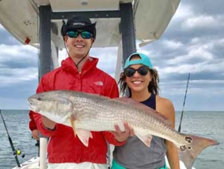 Fish Hunter Charters guests displaying a redfish