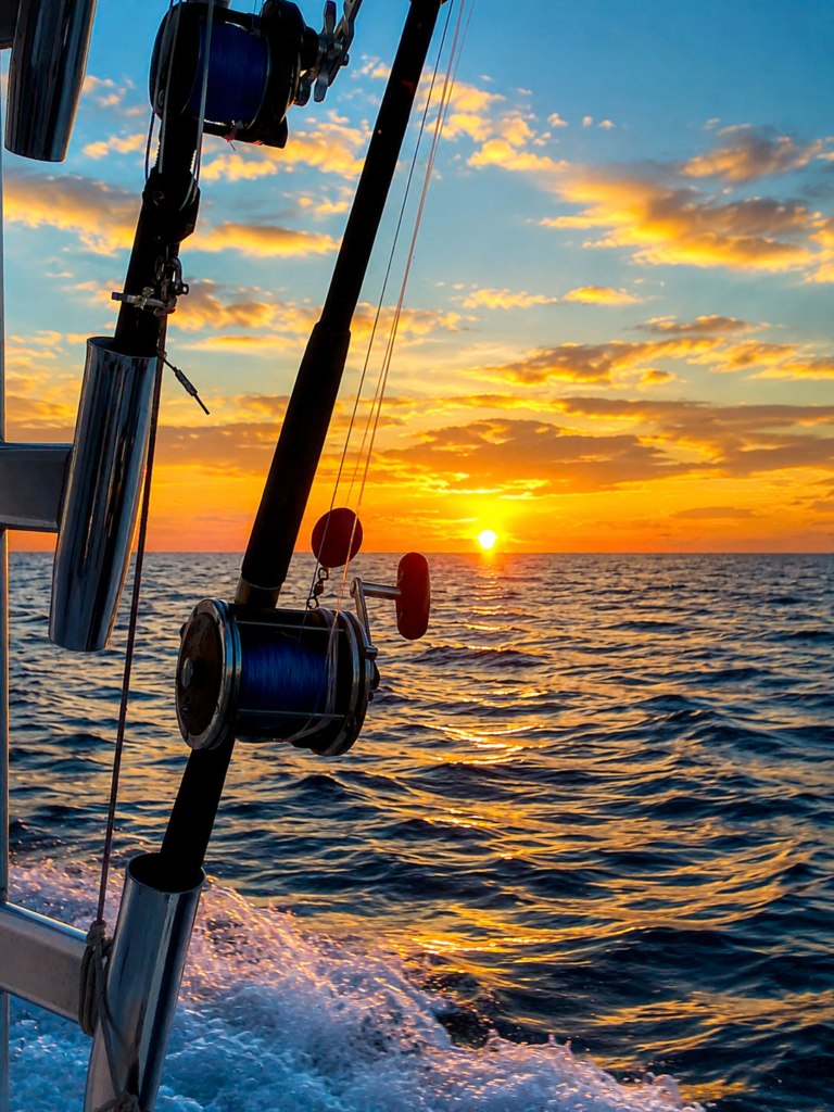 Fishing rods beside the boat at sunset