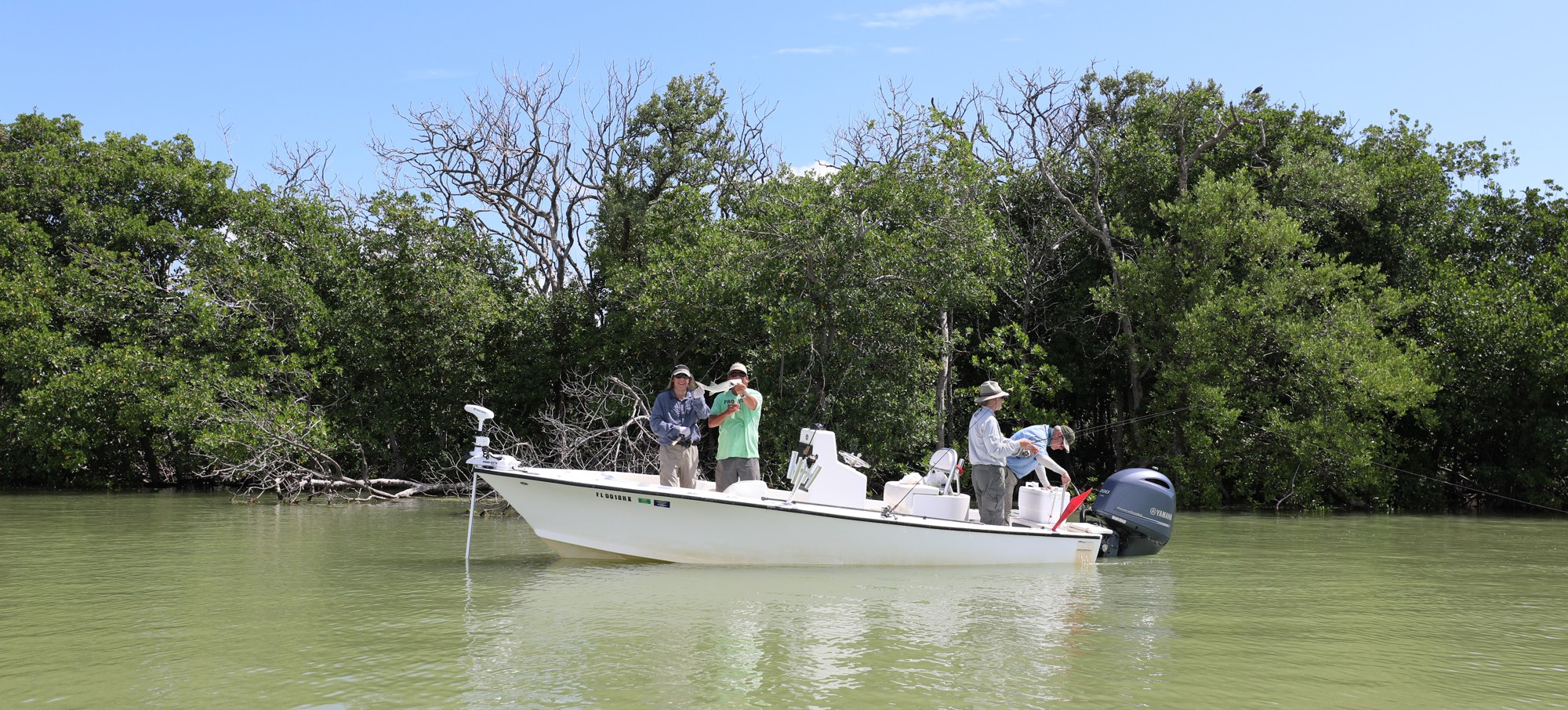 Anglers aboard a boat beside Everglades mangroves, from NPS Flamingo fishing information