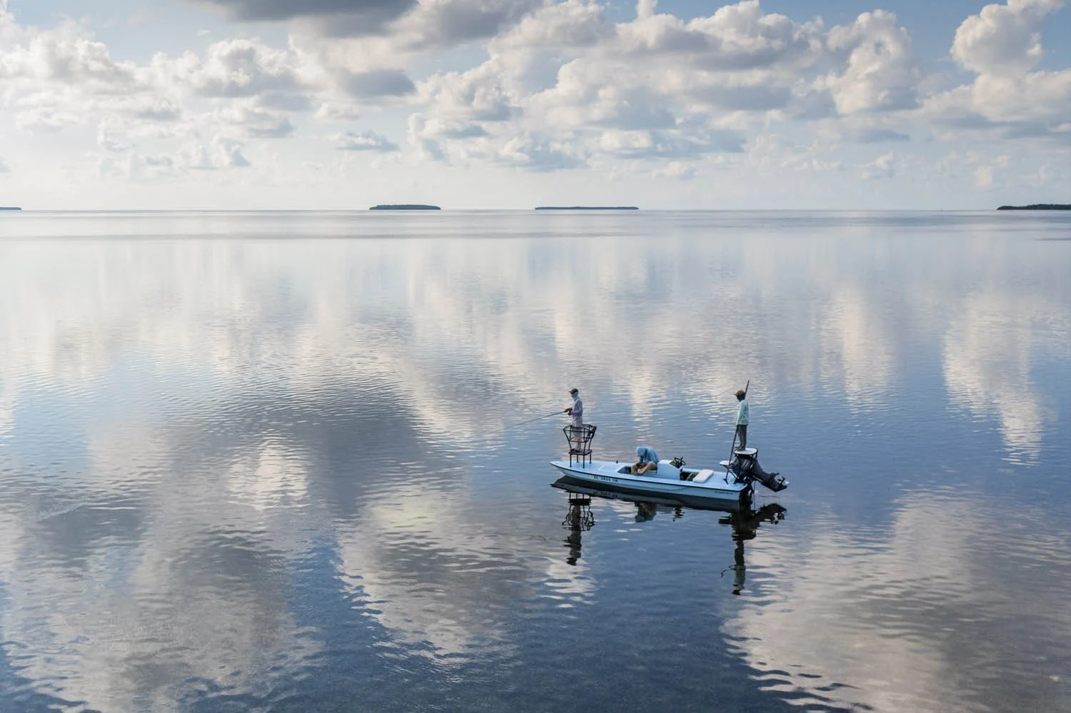 Flats fishing skiff reflected in calm water in a Key West Tarpon Guides photograph