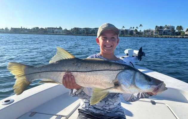 Flip and Rip guest displaying a snook aboard the boat