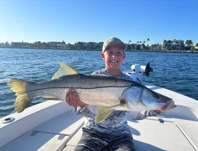 Flip and Rip guest displaying a snook aboard the boat