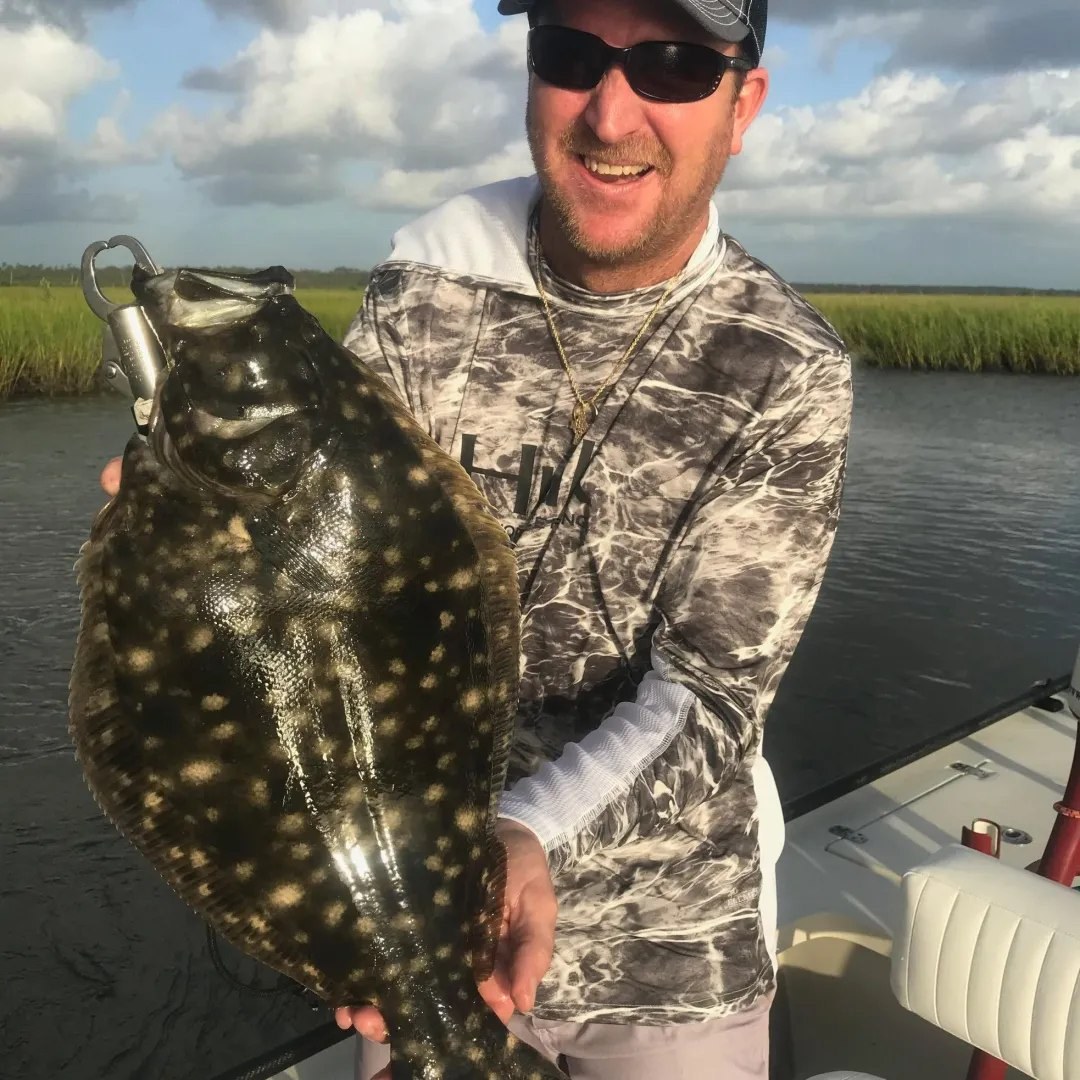 Three Lagoon Fishing Charters angler holding a flounder