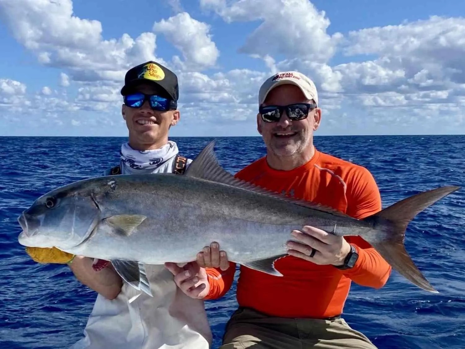Two anglers holding an amberjack aboard Reef Runner Sportfishing