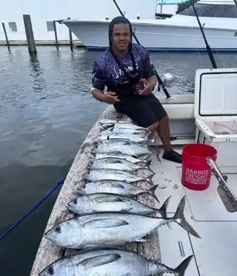 Guest beside a tuna catch aboard Don’t Panic Sportfishing