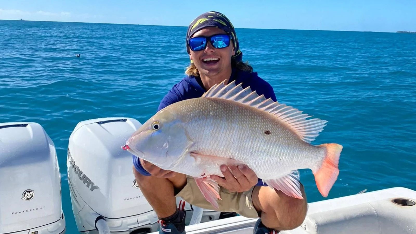 Guest holding a reef fish aboard Lilly II