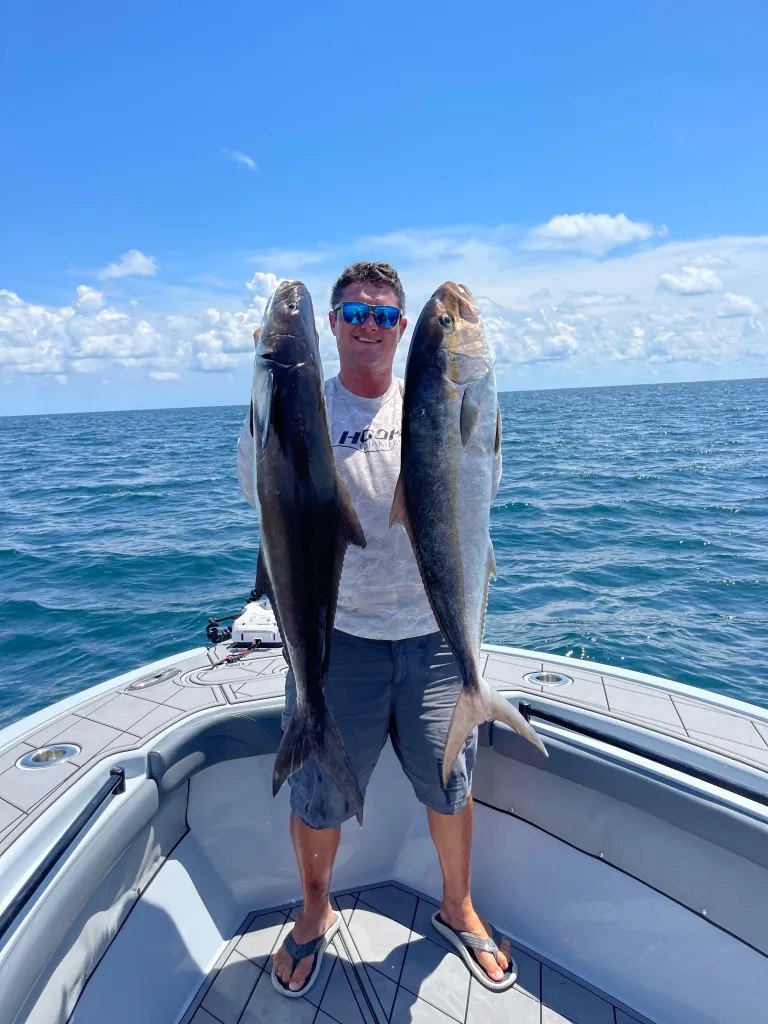 HookD angler holding two fish at the bow