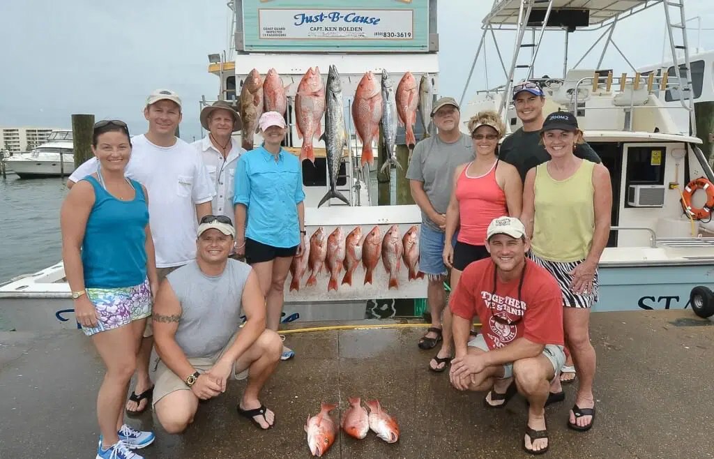 Just B Cause fishing party standing behind a dockside catch display