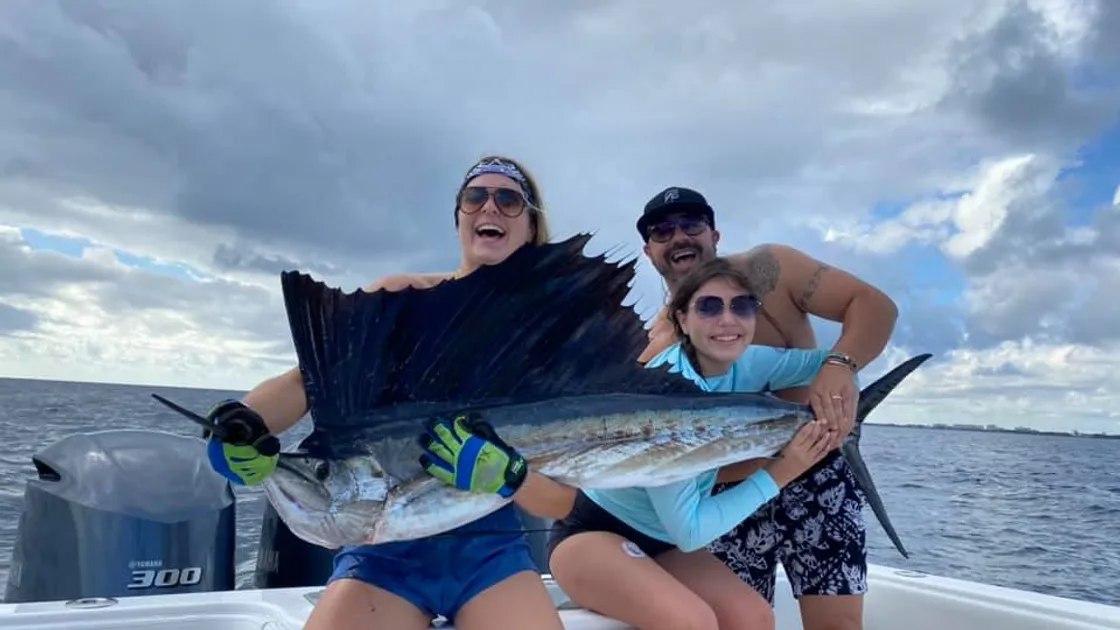 Lake Worth Beach Fishing Charters guests holding a sailfish