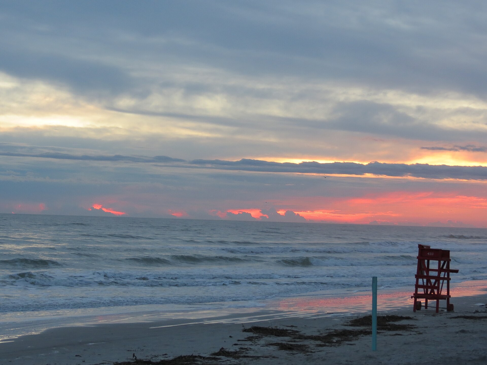 Sunrise over New Smyrna Beach beside a lifeguard chair