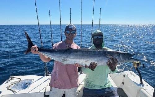 Salty Endeavors anglers displaying a long silver fish aboard the charter boat