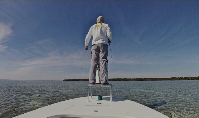 Shallow Tails guide poling a fishing skiff