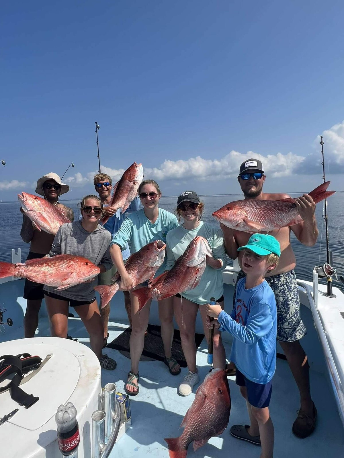 Snapper Trapper guests displaying their fishing catches aboard the boat