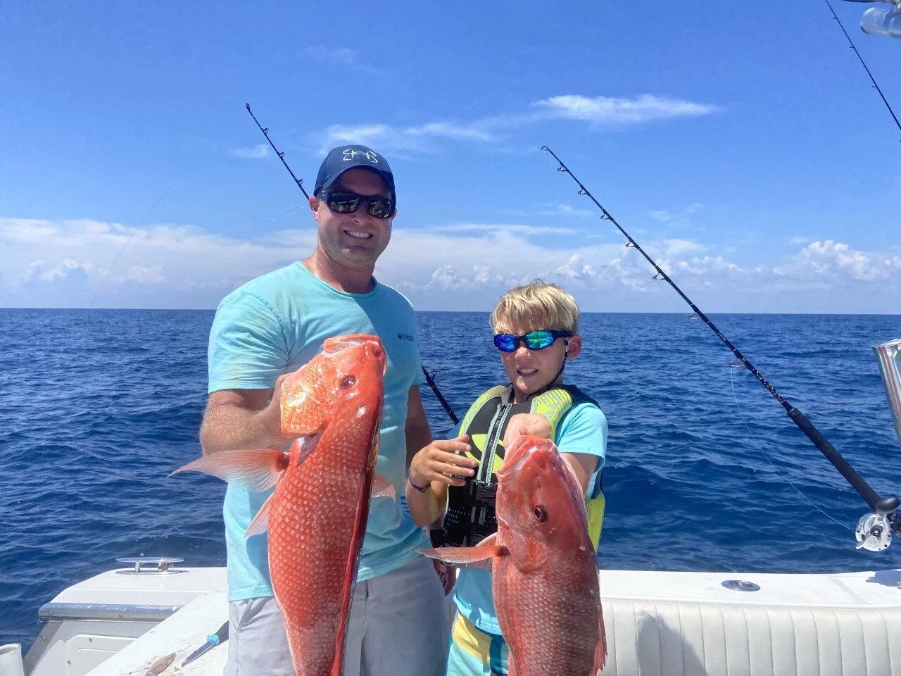 Southern Star adult and young angler holding red snapper