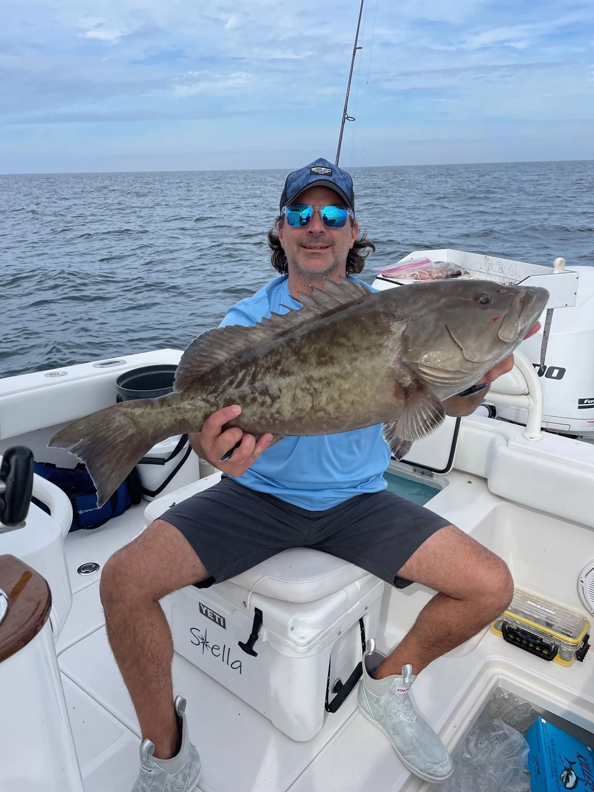 Stella Fishing Co angler holding a grouper